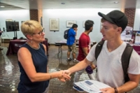 SIU Student shaking faculty hand in student center