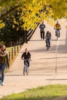 Students walking and riding bikes on campus bridge